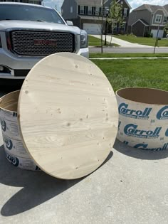 two buckets are sitting on the sidewalk next to a large wooden barrel that is being used as a planter