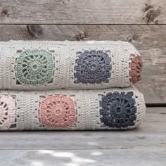 two crocheted pillows sitting next to each other on top of a wooden floor