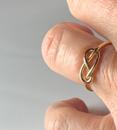 were highly symbolic in vintage jewelry, symbolizing infinite love. This would make a wonderfully unique wedding or engagement ring due to the romantic symbolism. The love knot/infinity knot represented the union of two souls arranged in the form of an infinity love knot. :) Ring weighs 1.3 grams. Band is stamped for 14k gold and is nice and sturdy despite it's dainty appearance. The ring is very comfortable to wear due to the low profile. The setting face measures 12.5 mm E to W and 8 N to S. C Dainty Metal Ring For Anniversary, Gold Infinity Jewelry, Gold Infinity Ring For Wedding, Gold Infinity Jewelry For Wedding, Symbolic Wedding Toe Ring Jewelry, Gold Infinity Ring Jewelry, Dainty Hand Forged Wedding Jewelry, Handmade Infinity Rings For Anniversary, Dainty Metal Ring For Wedding