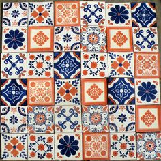 several different colored and patterned tiles on top of each other with orange, blue, and white designs