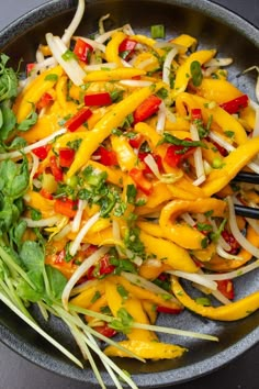 a pan filled with vegetables and greens on top of a table