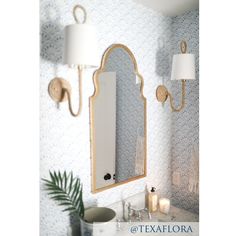 a white sink sitting under a bathroom mirror next to a wall mounted faucet