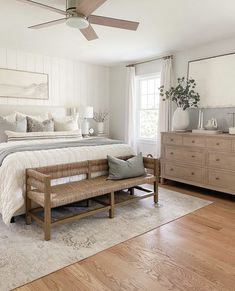 a bed room with a neatly made bed and a wooden bench