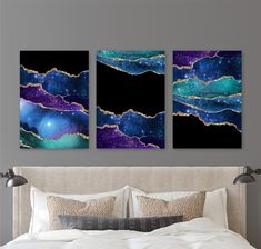 a bed with two paintings on the wall above it and a night sky in the background