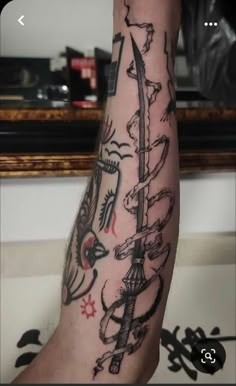 a man's arm with tattoos on it, and an arrow in the middle