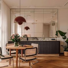 a dining room table with four chairs and a large mirror on the wall above it