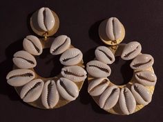 These are unique  Handmade chunky Cowrie shell hoop style Comfortable Clip on closure  handpainted gold wood hoops with hand applied cowrie shells  They hang 3 inches  Medium sized These are very lightweight on the ear Easy to wear They are one of a kind These Earrings are a classic and timeless addition to any  afrocentric wardrobe