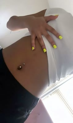 a woman's belly with yellow nail polish on it