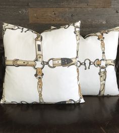 two pillows with chains on them sitting on a couch