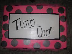 a pink and black polka dot frame with the words time out written on it in cursive writing