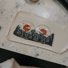 a white plate topped with two pictures on top of a marble counter next to a cup