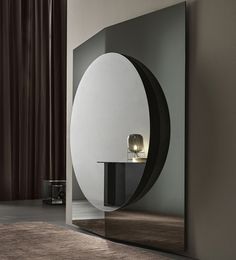 a large mirror sitting on the side of a wall next to a table and lamp