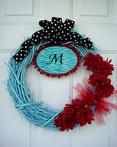 a blue and red wreath with the letter m on it, hanging from a door