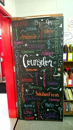 a blackboard with writing on it in front of a book shelf filled with books