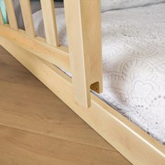 a wooden bed frame with white bedspread