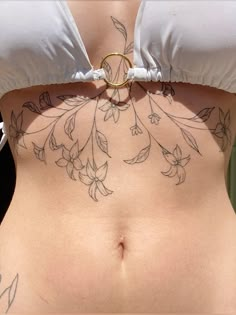 a woman's stomach with tattoos on it