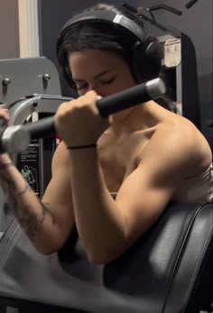 a woman with headphones on sitting in a gym