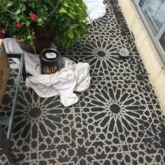 an outdoor patio with potted plants on the ground and other items scattered around it