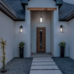 a white house with two lights on the front door