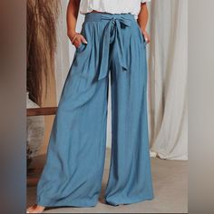 Introducing Our Stylish And Versatile Blue Wide Leg Pants For Women. Crafted With Utmost Care And Attention To Detail, These Pants Are Designed To Provide Both Comfort And Fashion-Forward Style. Made From High-Quality Fabric, They Offer A Flattering Fit And A Relaxed Silhouette That Effortlessly Complements Any Body Type. Whether You're Dressing Up For A Special Occasion Or Simply Want To Elevate Your Everyday Look, 100% Polyster Drawstring Closure Hand Wash Or Machine Wash Material: Linen And C High Waist Bottoms With Tie Waist In Solid Color, High Waist Solid Bottoms With Tie Waist, Solid Color High Waist Bottoms With Tie Waist, Solid High Waist Bottoms With Tie Waist, Relaxed Fit High Waist Bottoms With Tie Waist, Blue Non-stretch Vacation Pants, Summer Wide-leg Denim Blue Bottoms, Summer Wide-leg Denim Blue Pants, Summer Denim Blue Wide-leg Pants