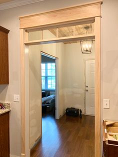 an empty room with hard wood flooring and white walls is seen from the doorway