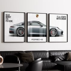 three porsche posters hanging on the wall above a black leather couch in a living room