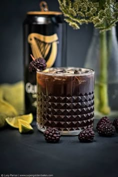 a chocolate cake with raspberries next to a can of guinness