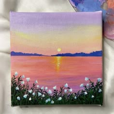 an acrylic painting of the sun setting over water with flowers in front of it