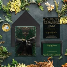 the wedding stationery is surrounded by evergreen branches and pine cones