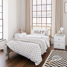 a child's bedroom with white walls and wood flooring, including a bed