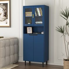 a blue bookcase in a living room next to a couch and potted plant