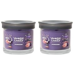 two purple candles sitting next to each other on top of a white surface with the words yankee