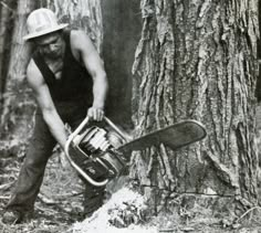 a man is holding a chainsaw near a tree