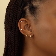 a close up of a woman's ear with two small earrings on top of it