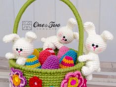 two crocheted rabbits in a basket with easter eggs