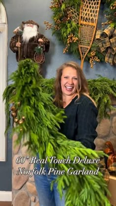 a woman is sitting on a couch with christmas decorations around her and the words, real touch deluxe nook pine garland