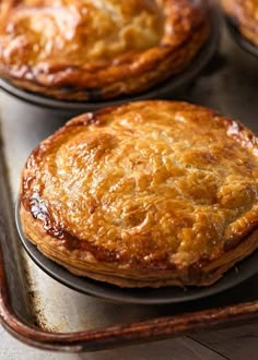 three baked pies sitting on top of a pan