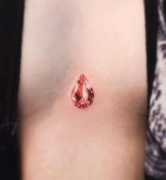 a woman's breast with a tear tattoo on it