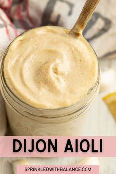 a mason jar filled with dijon aioli and topped with a wooden spoon