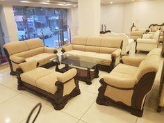 a living room filled with lots of furniture in front of a large glass wall window