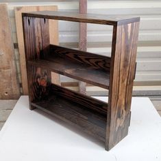 a wooden shelf sitting on top of a white table