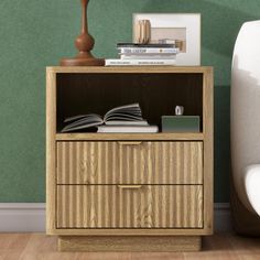 an open book is sitting on top of a wooden cabinet next to a white couch