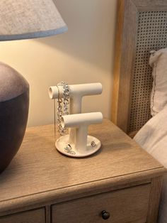 a lamp on a night stand next to a bed