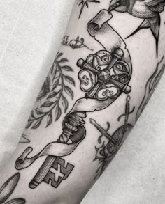 a black and white photo of a person's arm with tattoos on it