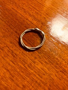 a silver ring sitting on top of a wooden table