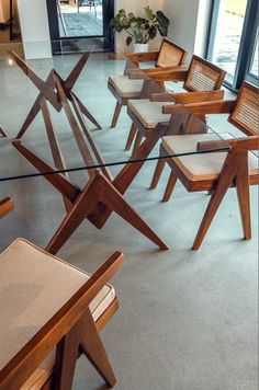 a glass table with wooden chairs in front of it