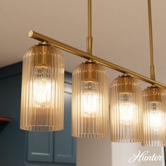 three lights hanging from a ceiling in a kitchen