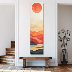 a painting hanging on the wall next to a wooden bench in a room with white walls