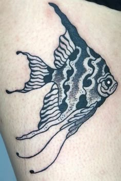 a black and white fish tattoo on the thigh