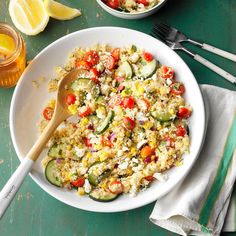 a white bowl filled with couscous and vegetables next to two bowls of lemonade